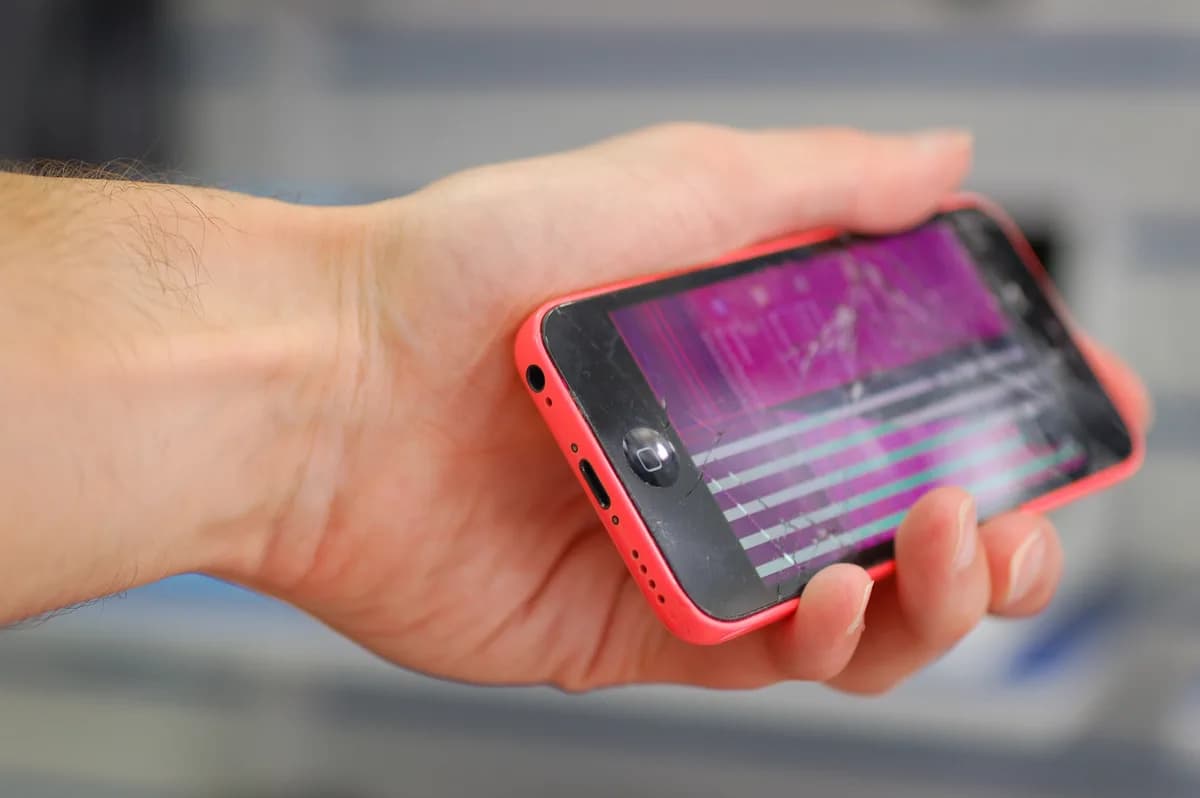 Telefon, amelynek kijelzőjén rózsaszín foltok és vízszintes csíkok látszanak — sérült panel